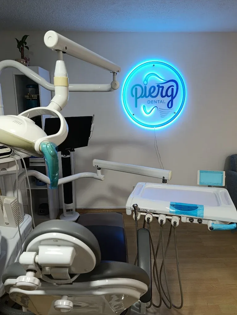 Sillón odontológico y logotipo iluminado en el consultorio de Pierg Dental.